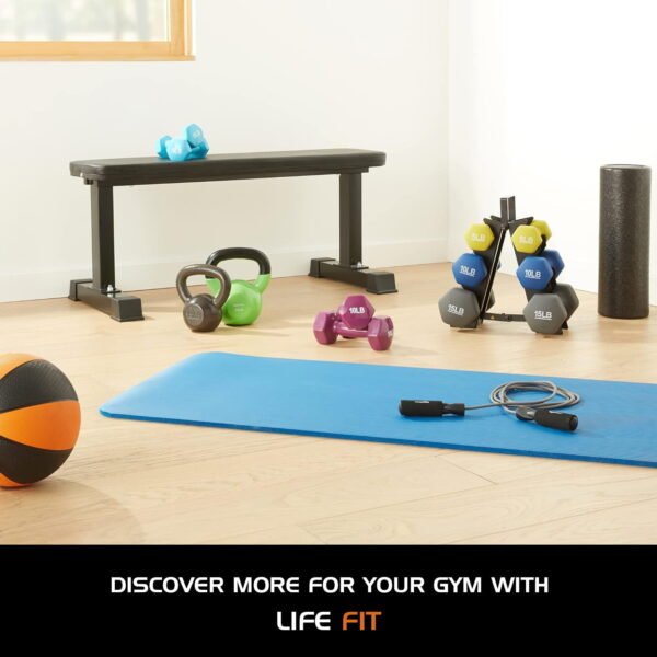 A well-equipped gym featuring a diverse range of exercise machines, weights, vinyl kettlebell and workout stations.