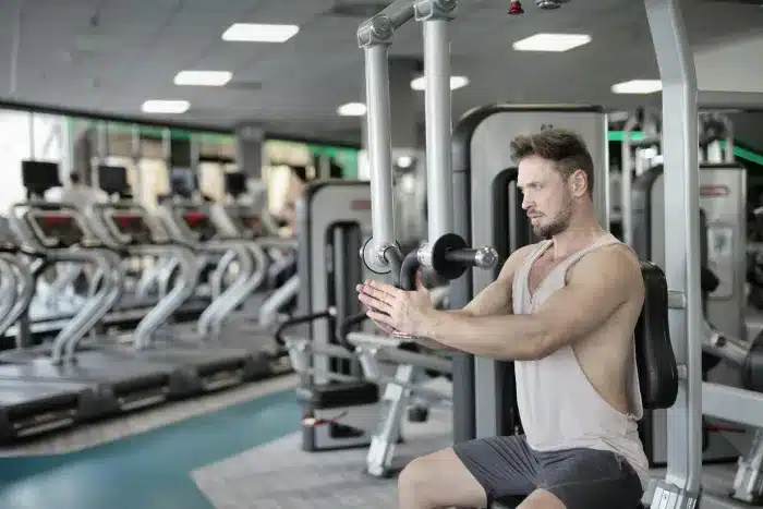 a man doing chest exercise with pec deck fly machine