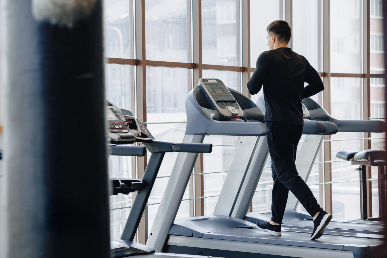 Man running on a treadmill, incorporating cardio into his workout routines for men.