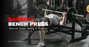 A person performing the barbell bench press exercise on a flat bench inside a gym. Text overlay reads 'BARBELL BENCH PRESS: Exercise Guide, Safety & Progress. lifefitindia.com'.