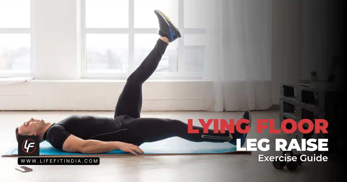 Side profile of a man in black athletic wear performing a lying floor leg raise on a blue exercise mat in a brightly lit room with large windows. Text overlay reads: LYING FLOOR LEG RAISE Exercise Guide. LIFE FIT INDIA logo in bottom left.