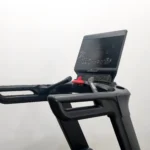 A close-up view of the LIFE FIT LF-8700 treadmill's user console, showing the large display screen, control buttons, handlebars with integrated sensors, and the red emergency stop key.