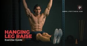 A muscular man demonstrates the proper form for a hanging leg raise exercise, hanging from a bar with his knees raised towards his chest.