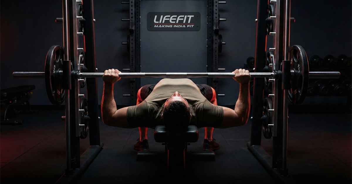 Male athlete performing the Smith Machine Bench Press with proper grip, bar path, and chest engagement in a commercial gym.